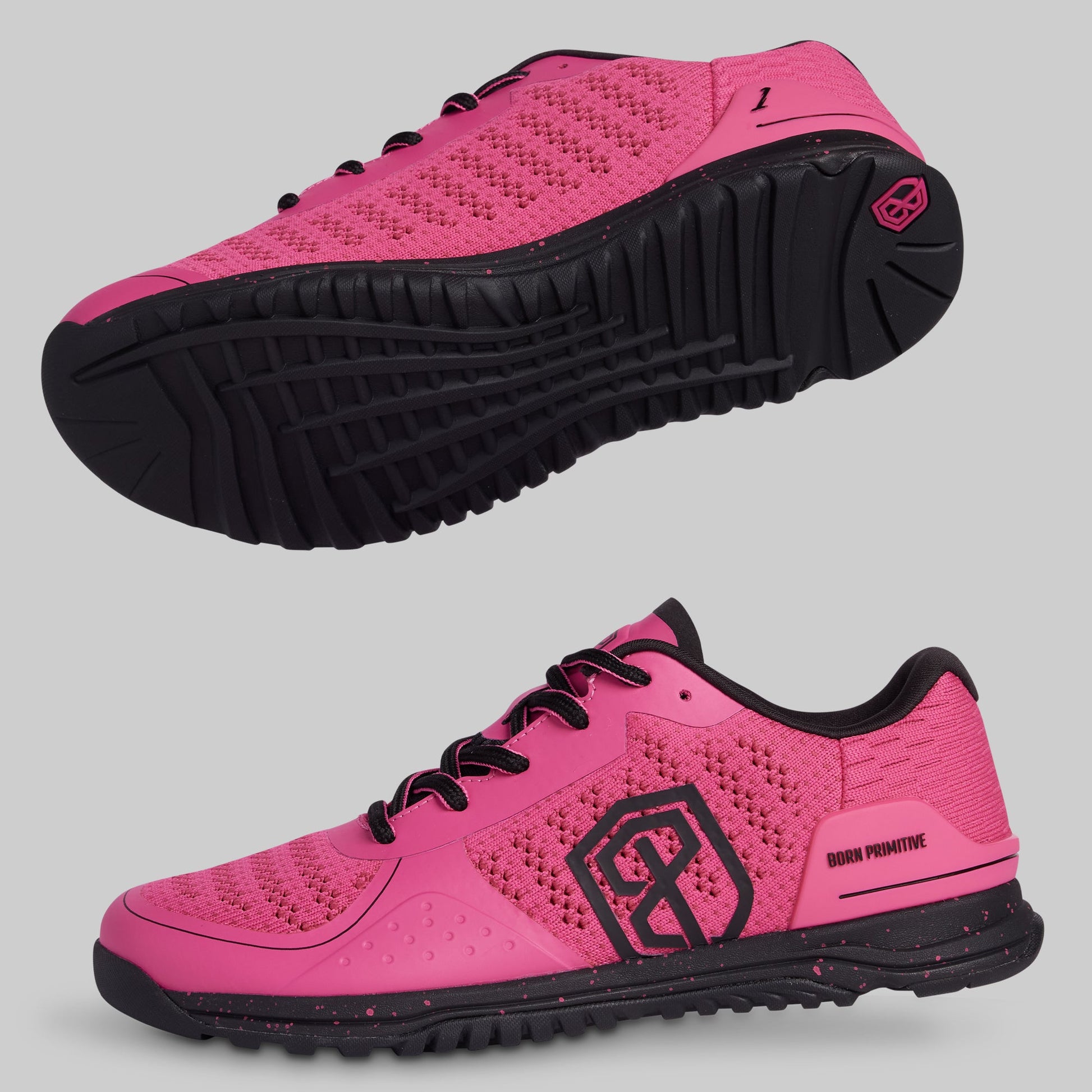 Pink athletic shoes with black soles on a gray background