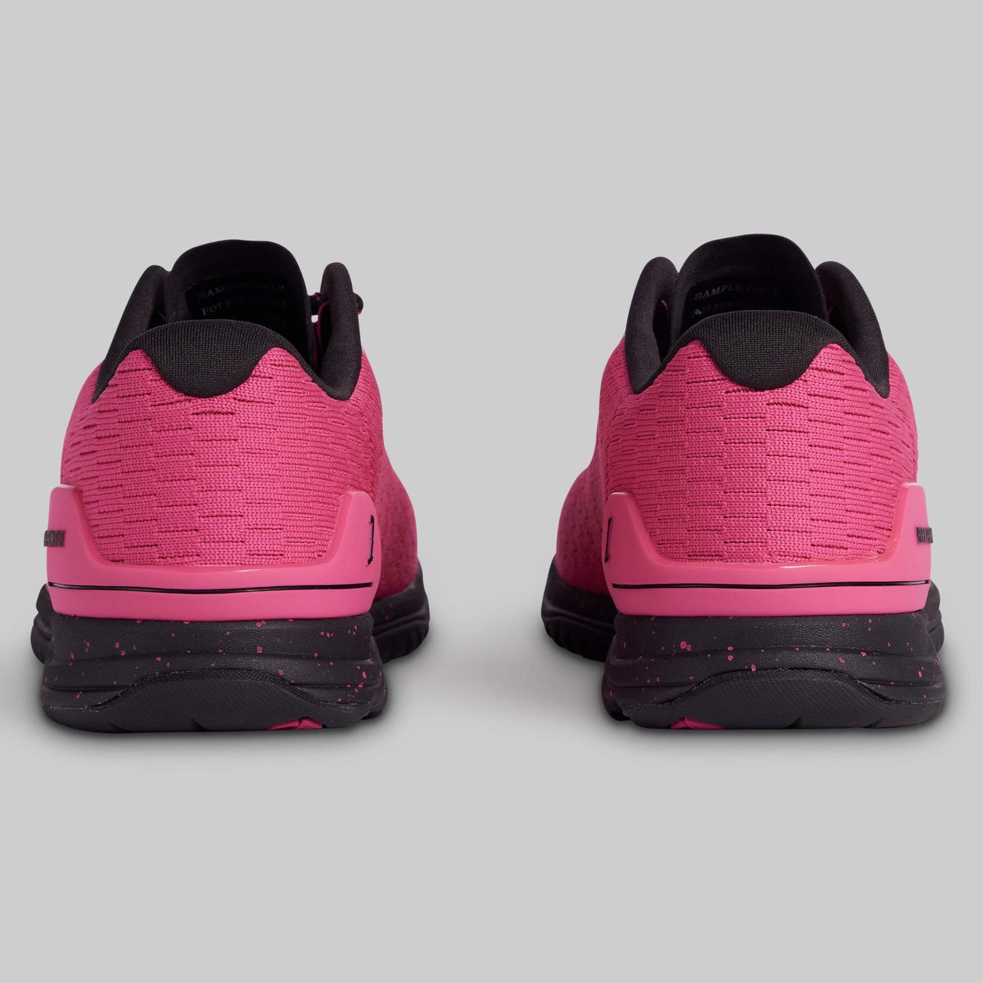 Pink and black athletic shoes shown from the back on a light gray background