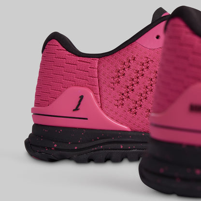 Pink and black athletic shoe on a light gray background
