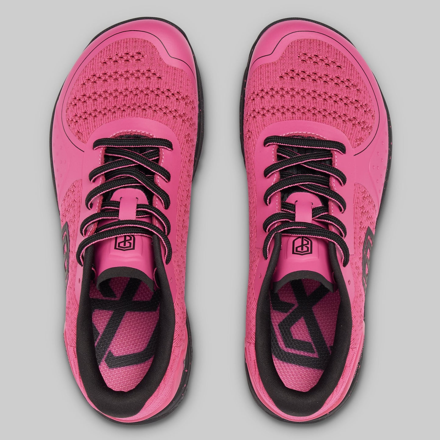 Pair of pink running shoes with black accents on a gray background