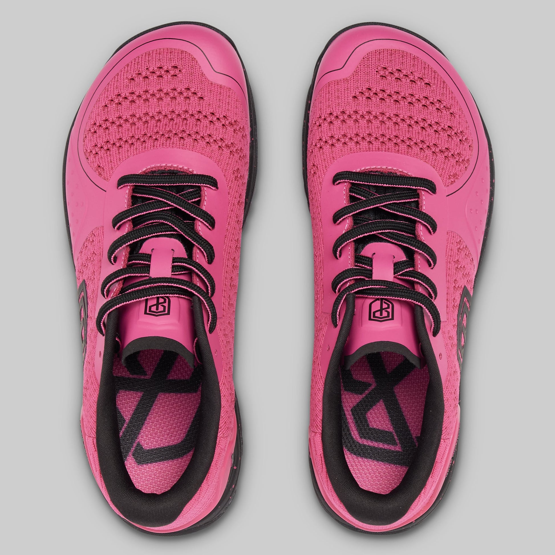 Pair of pink running shoes with black accents on a gray background