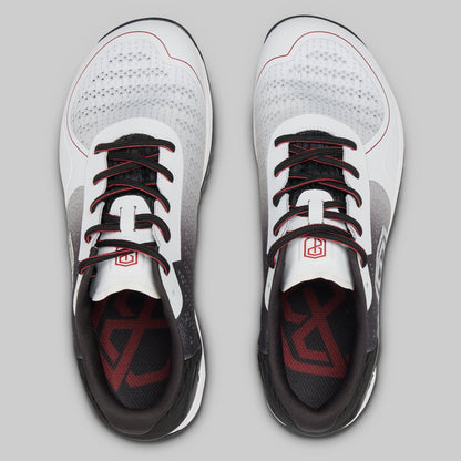 White athletic shoes with black and red accents on a gray background
