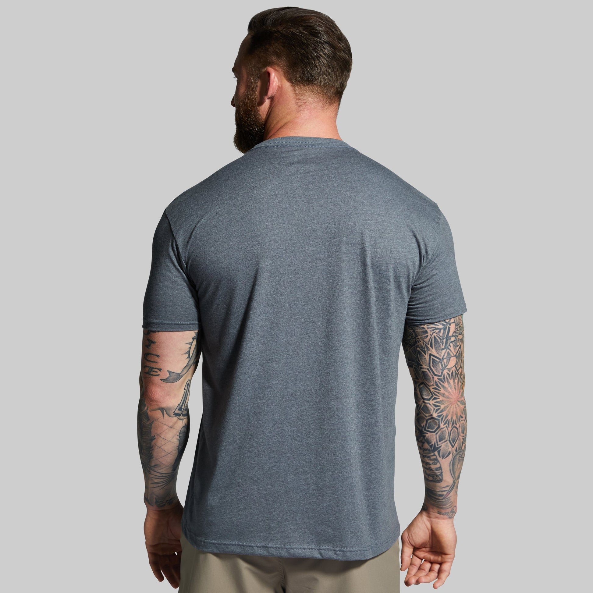 Man wearing a gray t-shirt against a plain background