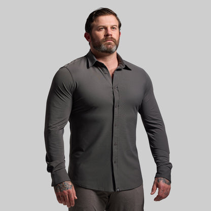 Man wearing a gray long-sleeve shirt against a plain background
