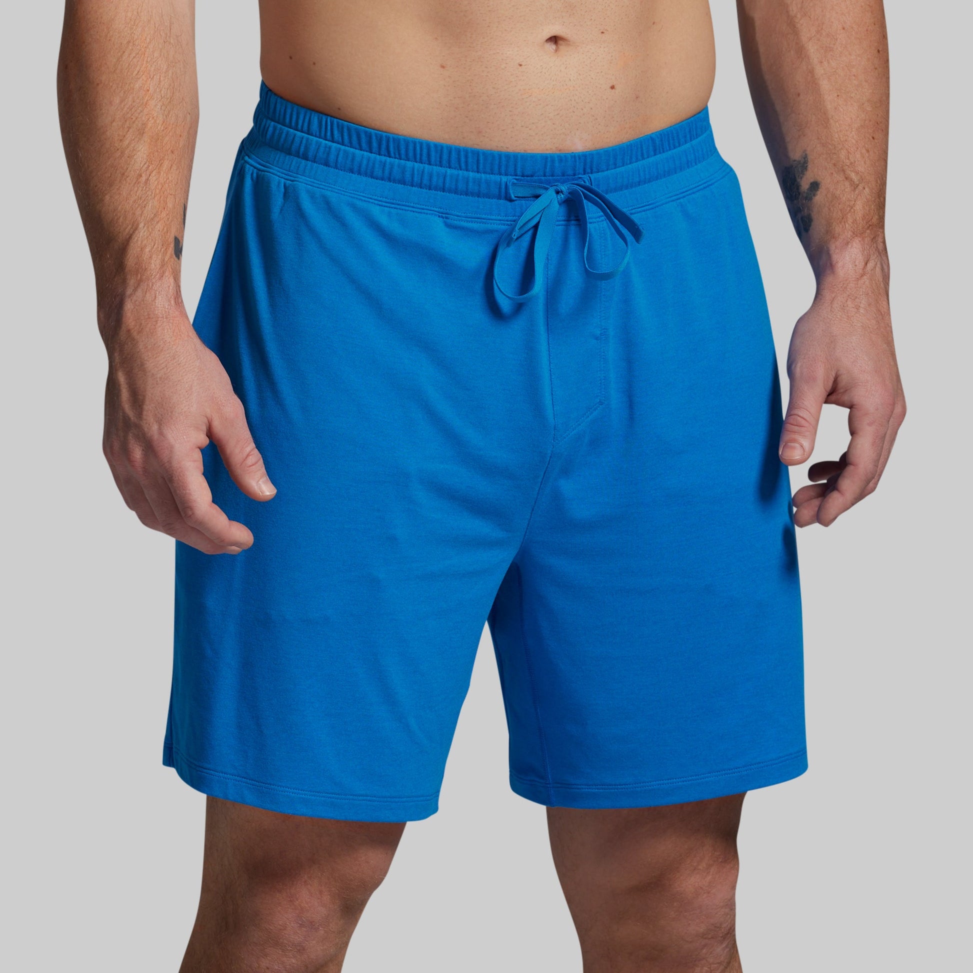 Blue shorts worn by a person on a gray background