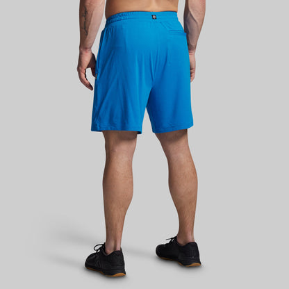 Person wearing blue athletic shorts on a gray background