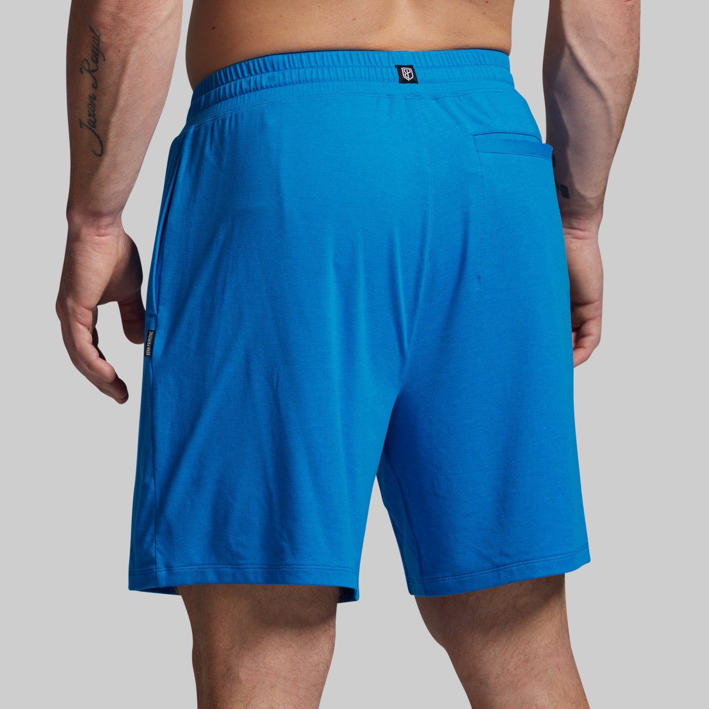 Blue shorts worn by a person on a gray background