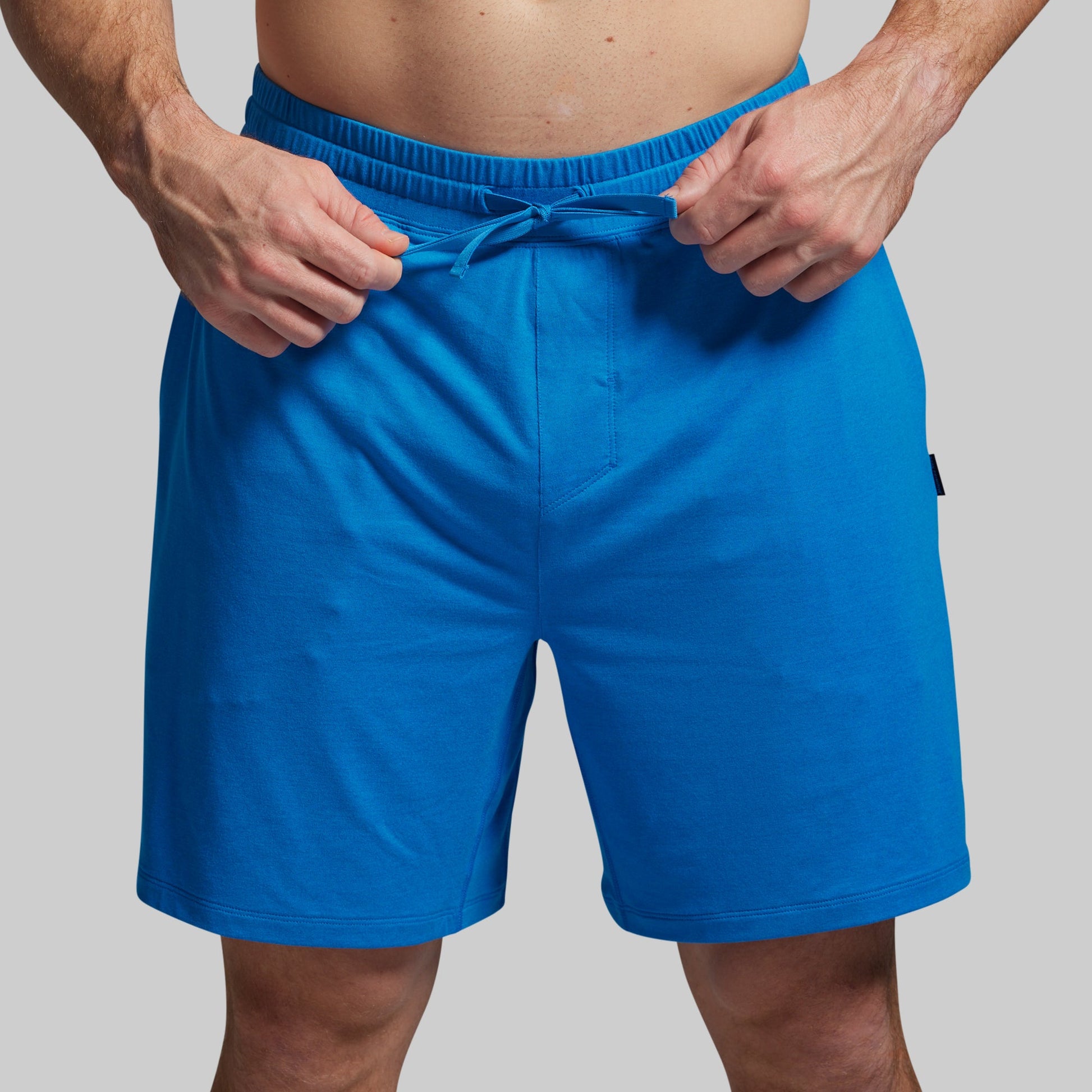 Person wearing blue shorts on a gray background