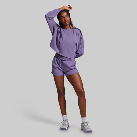 Person wearing a purple outfit on a gray background