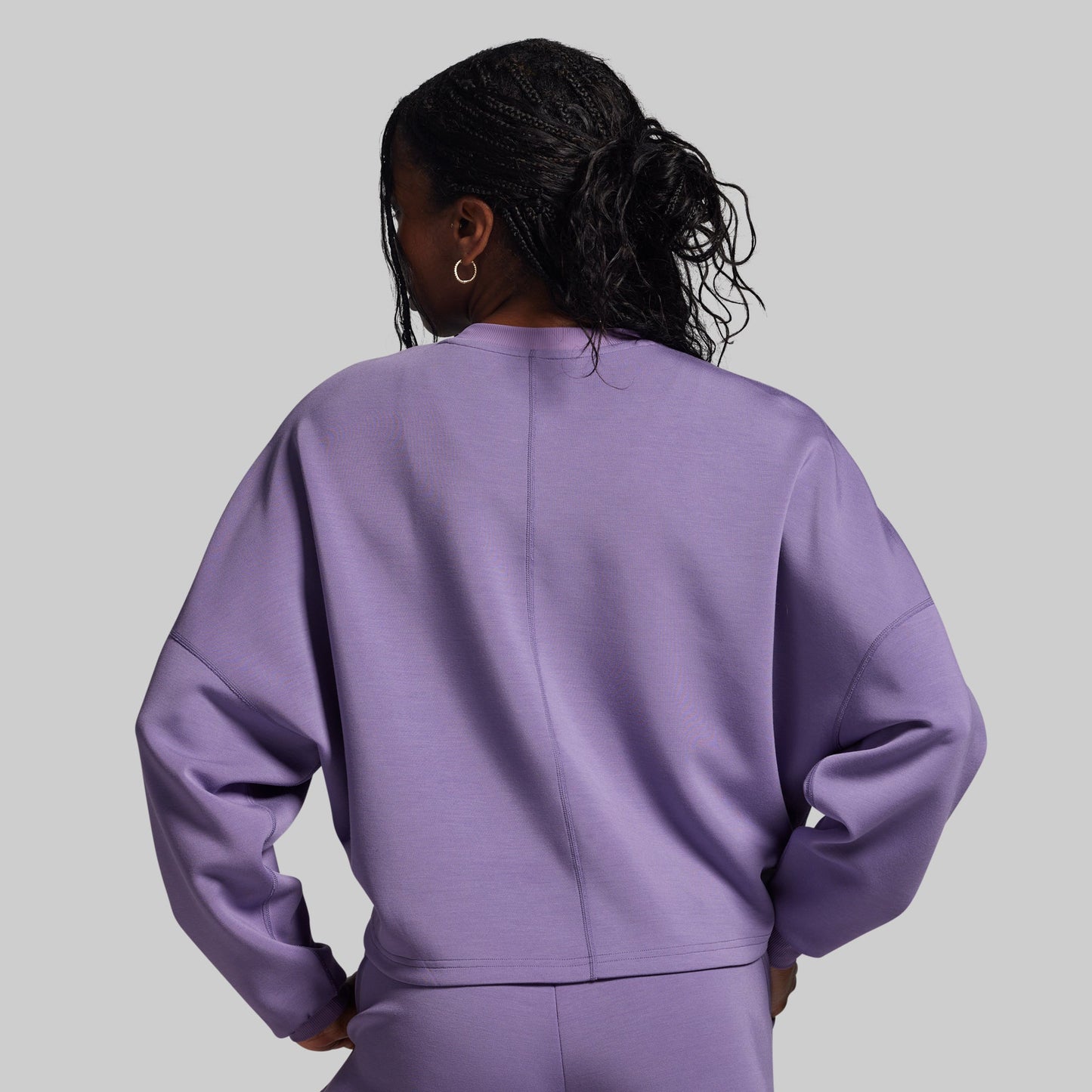 Person wearing a purple outfit against a gray background