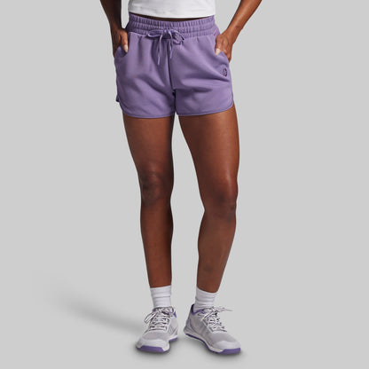 Person wearing purple shorts on a gray background