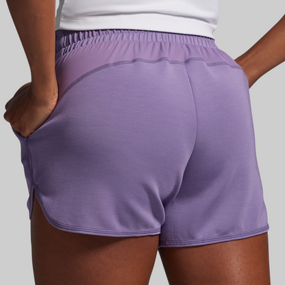 Purple athletic shorts worn by a person on a light gray background