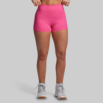 Person wearing bright pink athletic shorts on a gray background