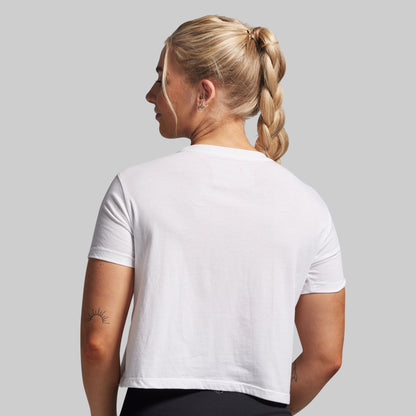 Person wearing a plain white t-shirt on a light gray background