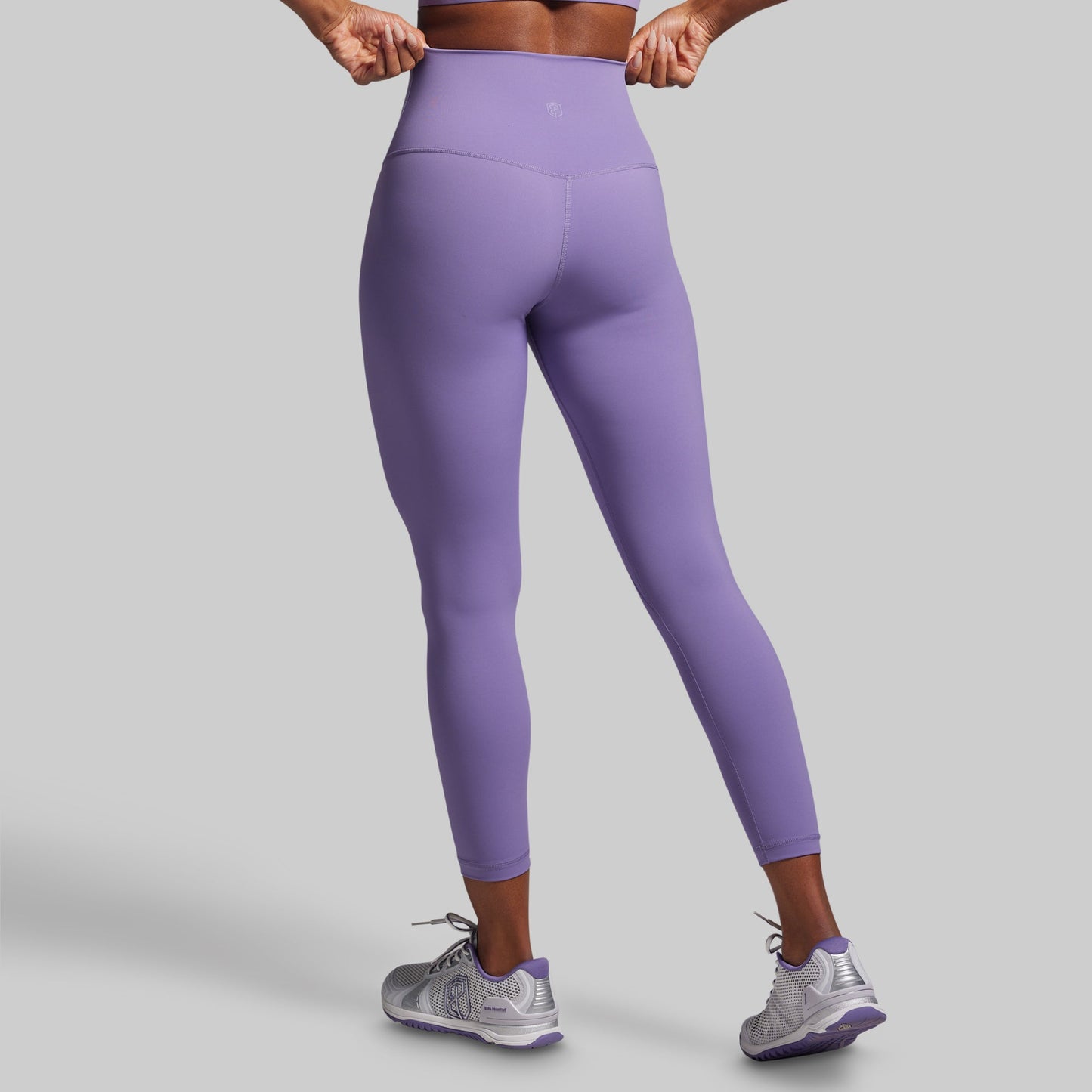 Person wearing purple leggings on a gray background