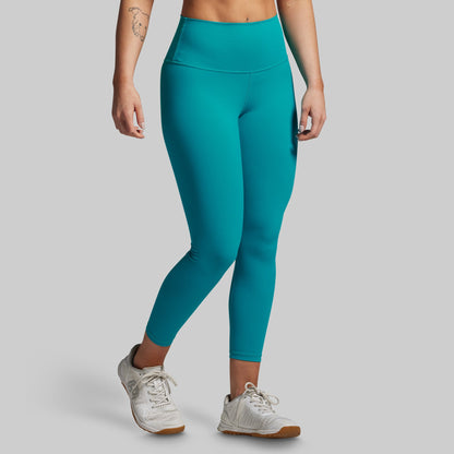 Teal leggings worn by a person on a gray background