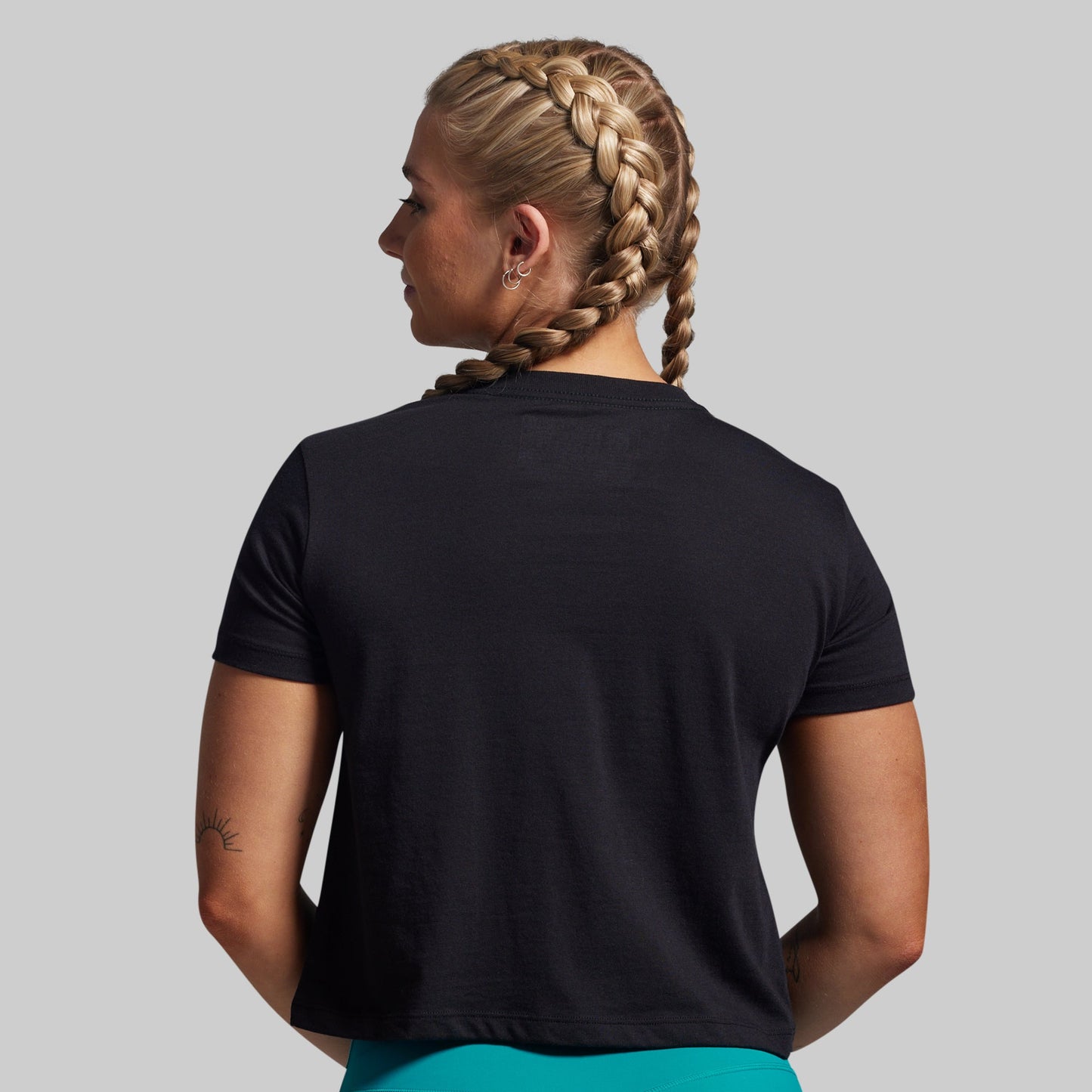 Person wearing a black t-shirt on a plain background