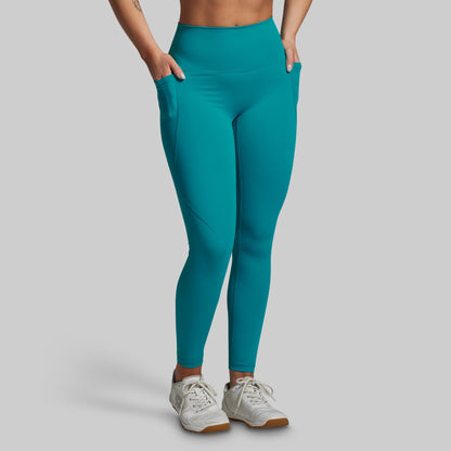 Teal leggings worn by a person on a gray background