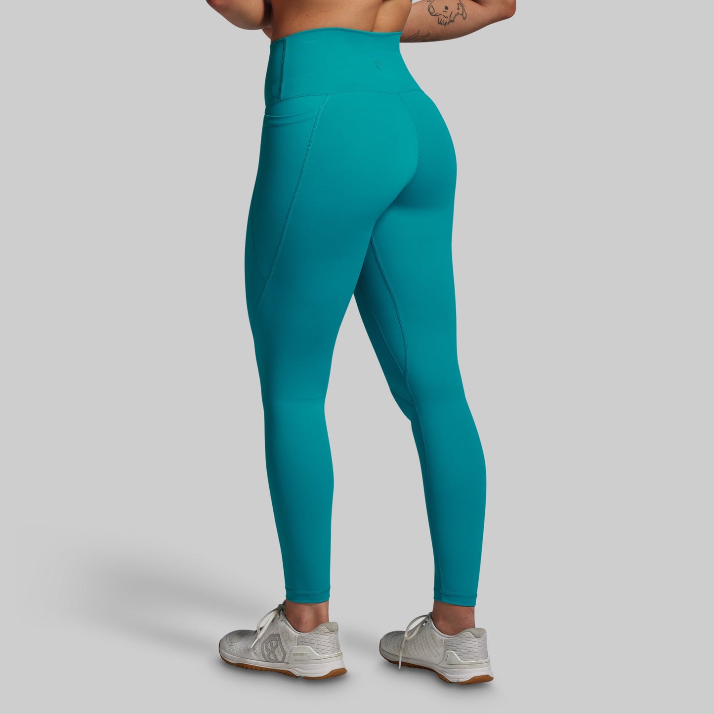 Teal leggings worn by a person on a plain background