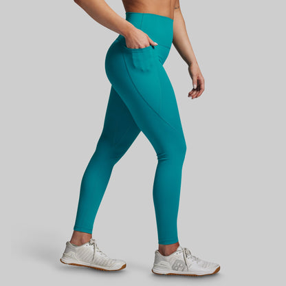 Teal leggings worn by a person on a gray background