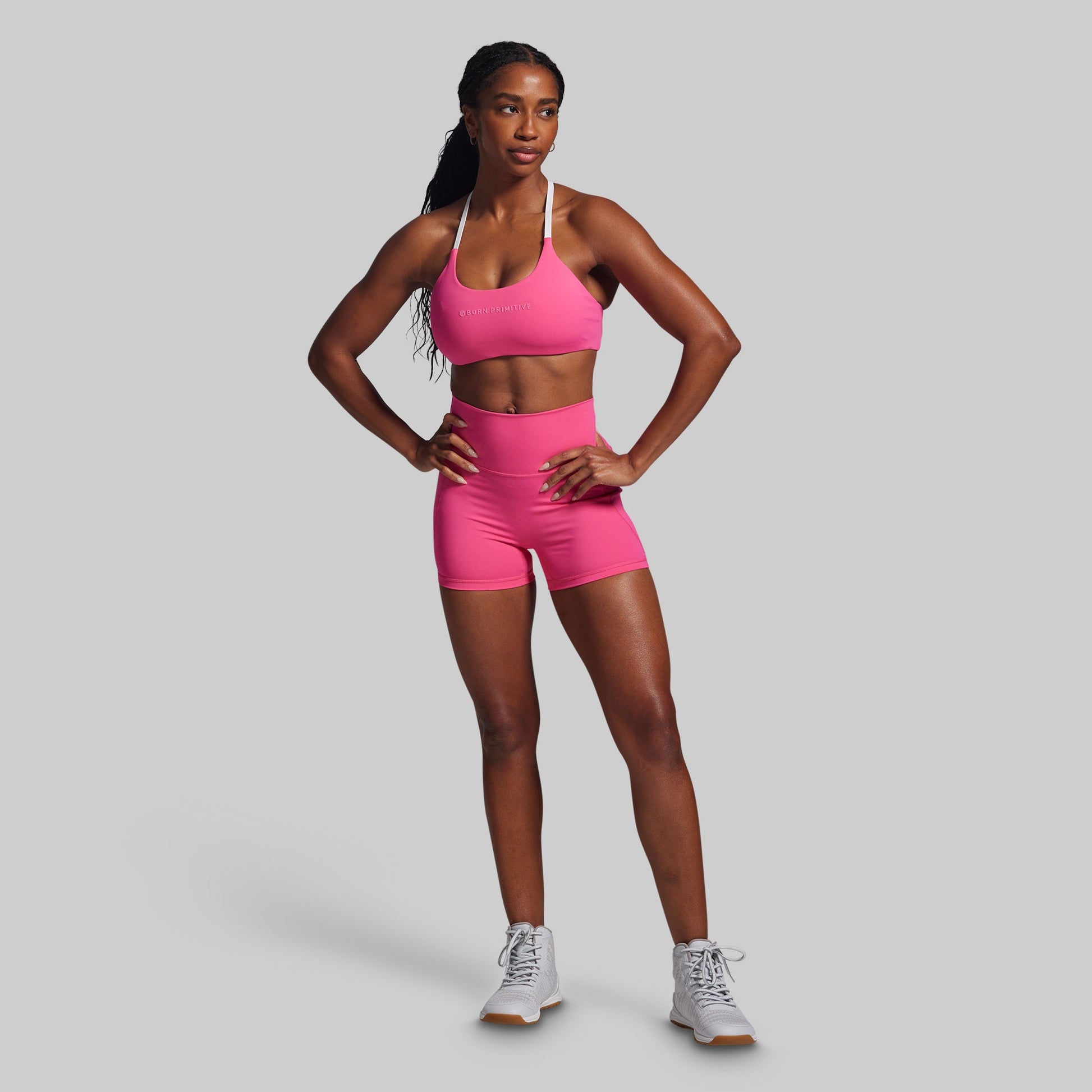 Woman wearing a pink athletic outfit on a gray background