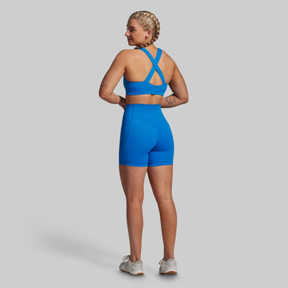 Woman wearing a blue athletic outfit on a gray background