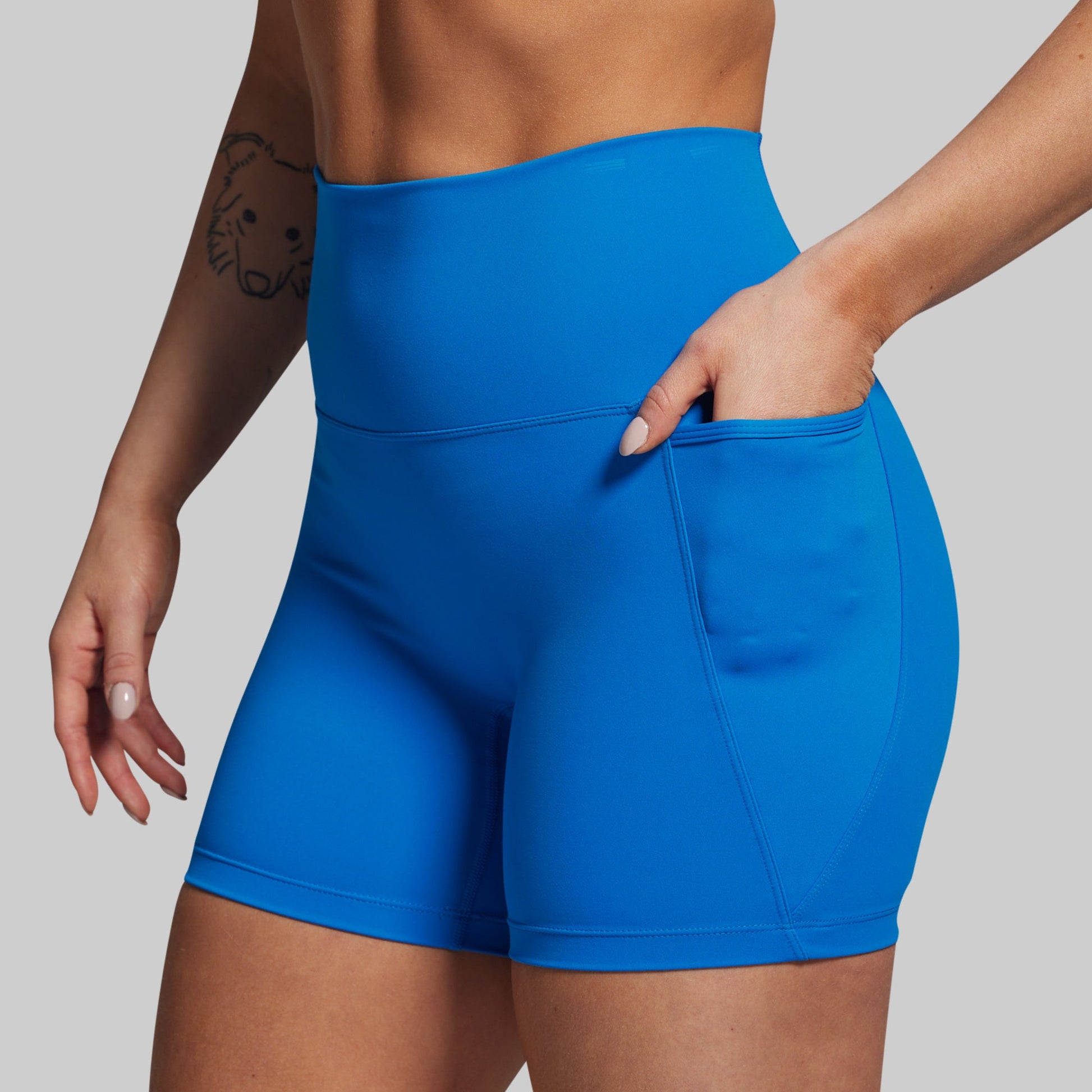 Blue athletic shorts worn by a person on a plain background