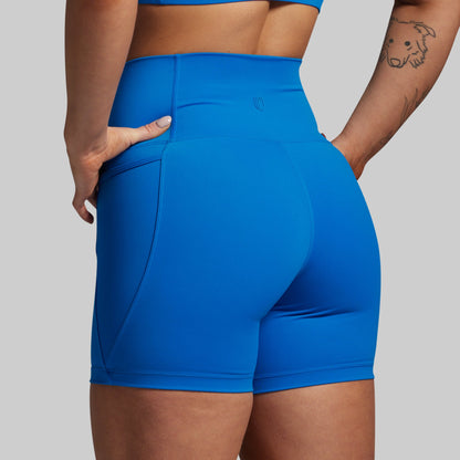 Blue athletic shorts worn by a person on a plain background