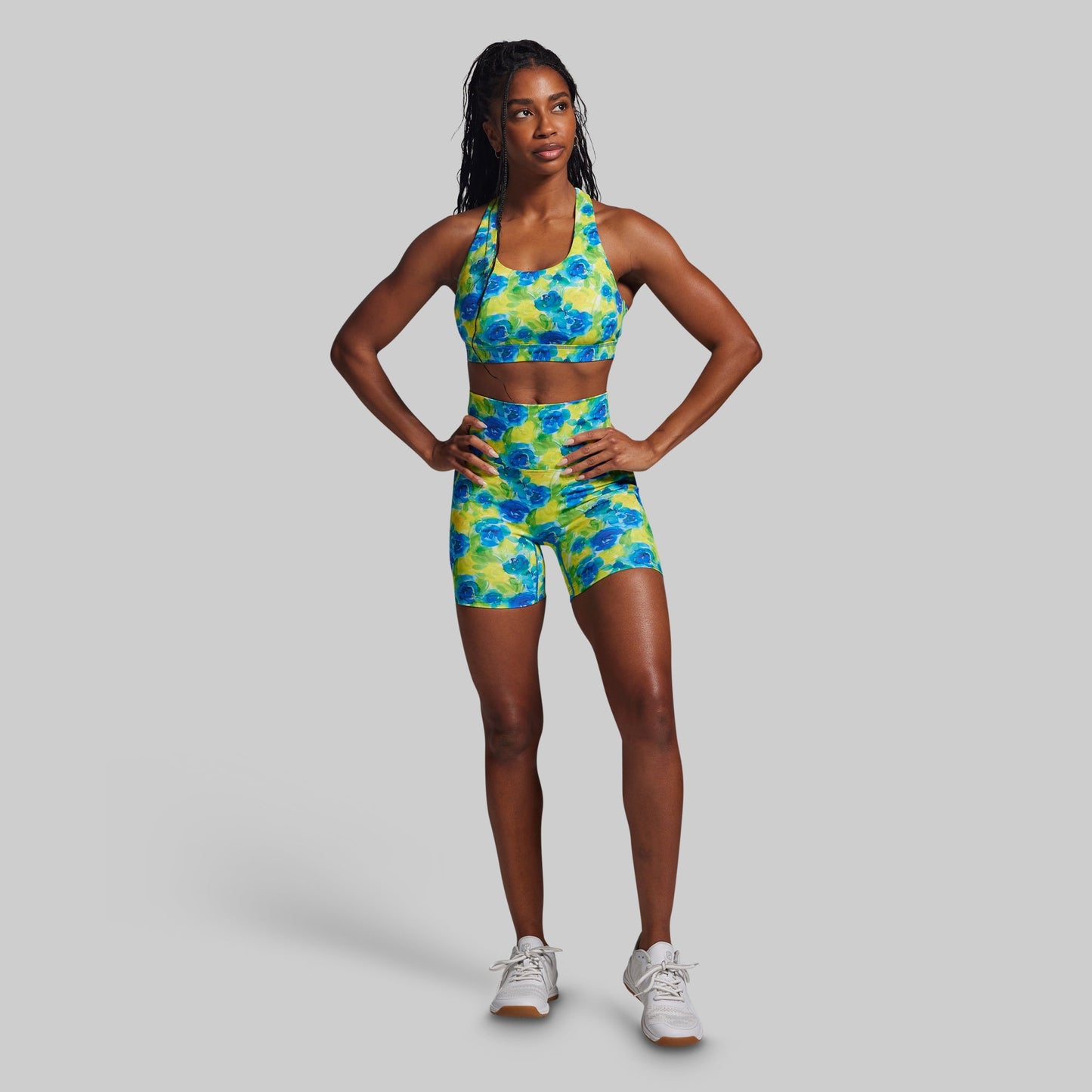 Woman wearing a colorful athletic outfit on a gray background