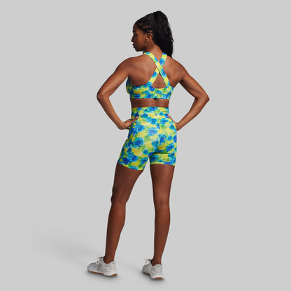 Woman wearing a colorful floral sports outfit on a gray background