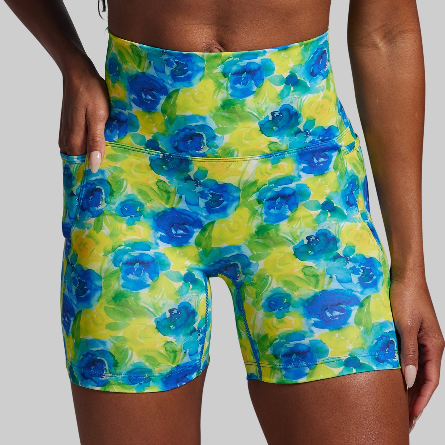 Floral patterned shorts with blue and green flowers on a plain background
