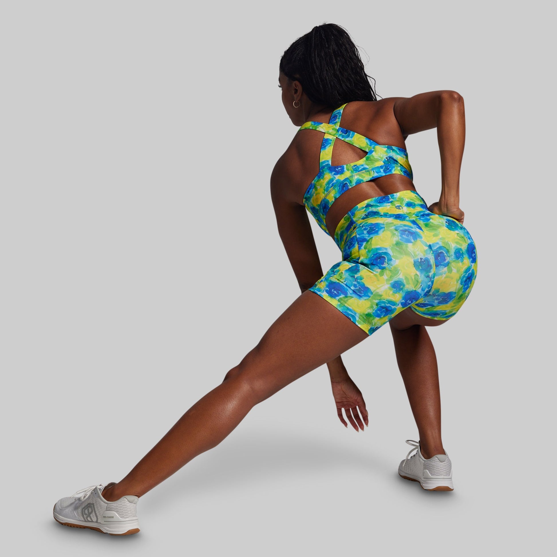 Person wearing a colorful floral sports outfit on a gray background
