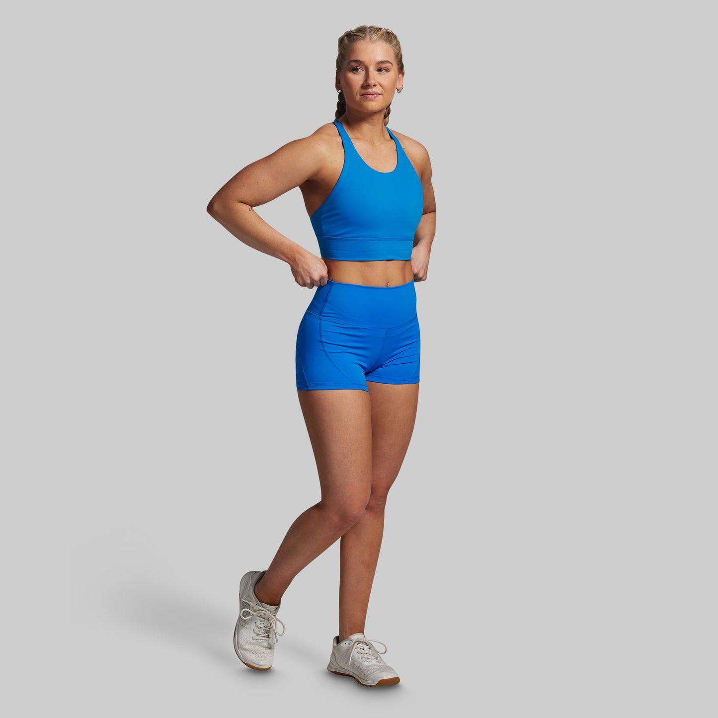 Woman wearing a blue athletic outfit on a gray background