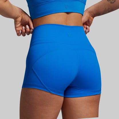 Person wearing blue athletic shorts and top on a plain background