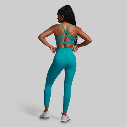 Person wearing a teal sports outfit on a gray background