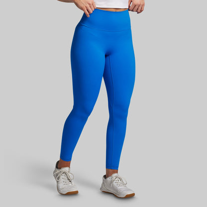 Blue leggings worn by a person on a gray background