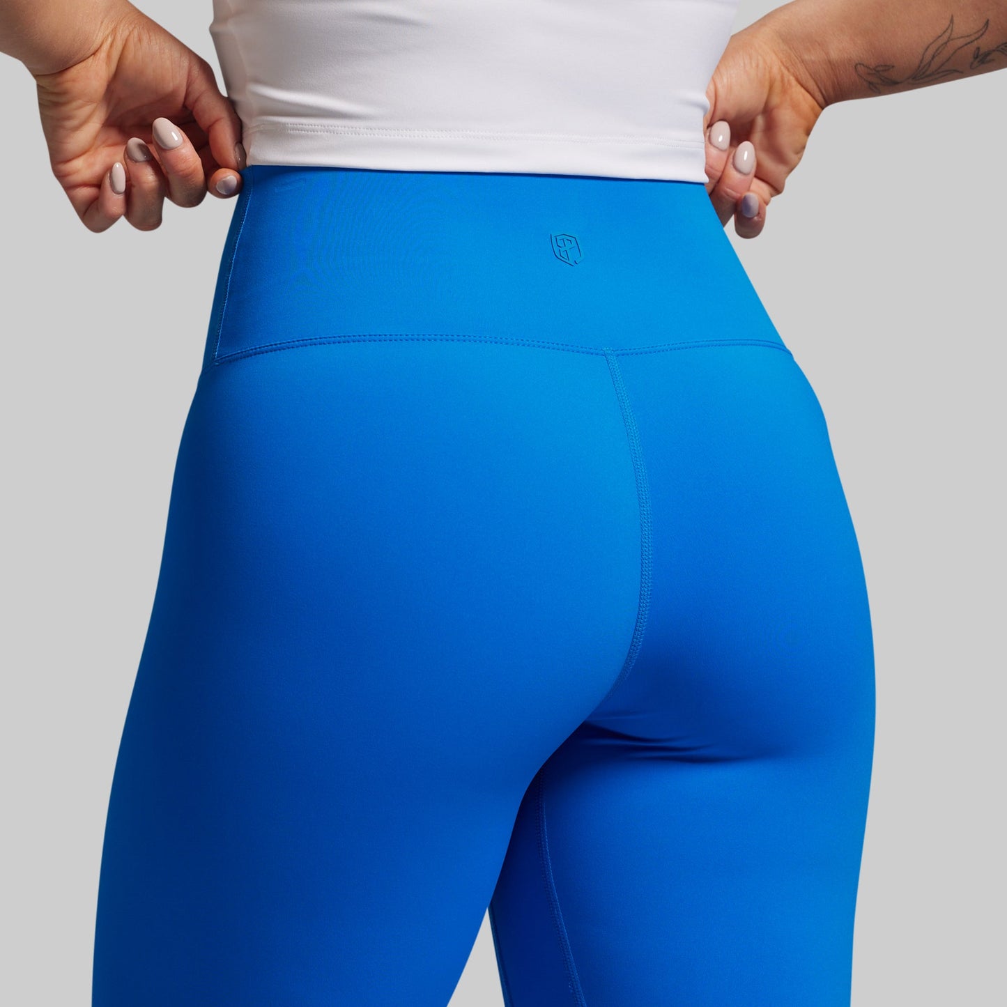 Blue leggings worn by a person on a plain background