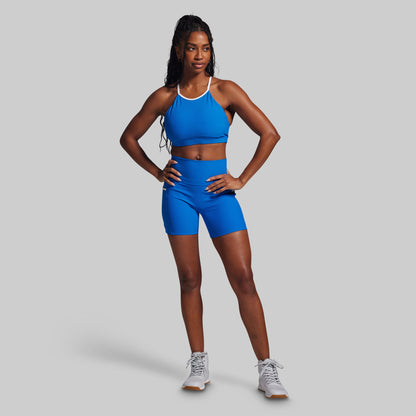 Woman wearing a blue athletic outfit on a gray background