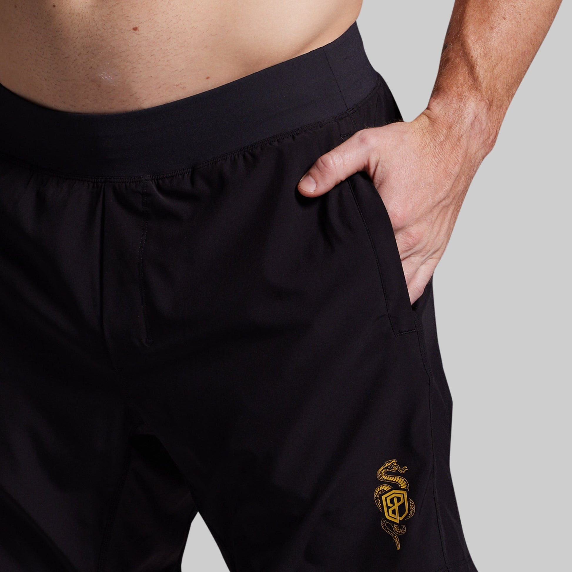 Black shorts with a yellow logo on a gray background