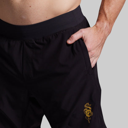 Black shorts with a yellow logo on a gray background