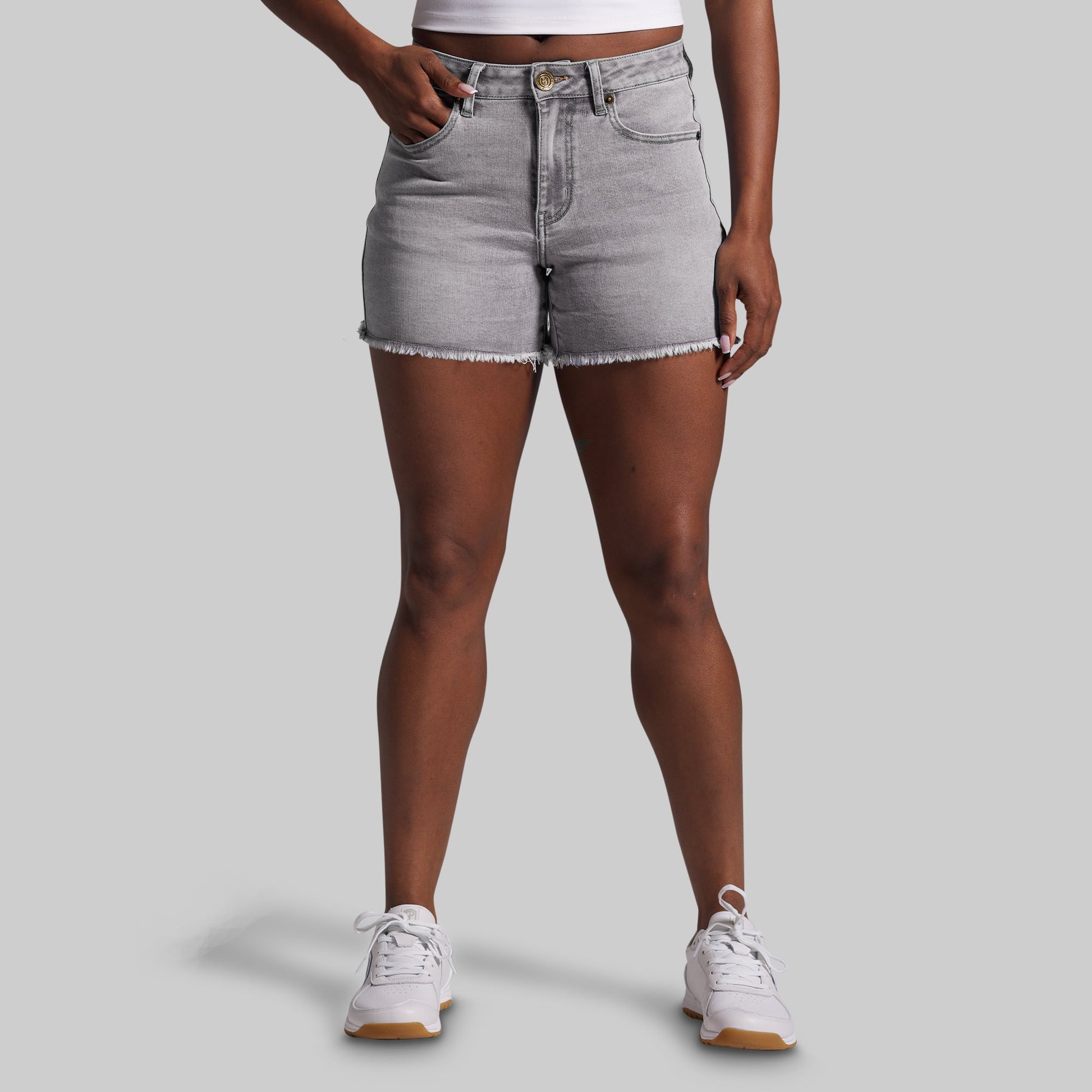 Person wearing gray denim shorts on a light gray background