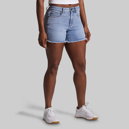 Person wearing light blue denim shorts on a gray background