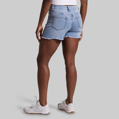 Person wearing light blue denim shorts on a gray background