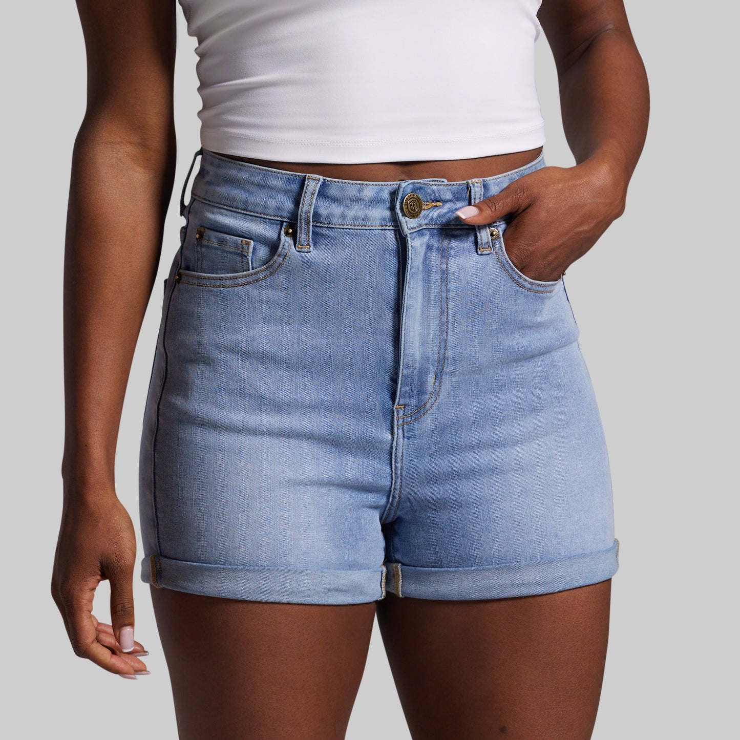 Person wearing light blue denim shorts on a plain background