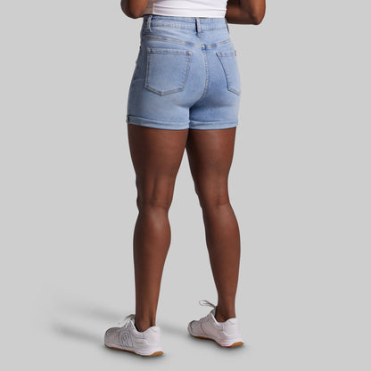 Person wearing light blue denim shorts on a gray background