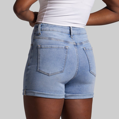 Person wearing light blue denim shorts on a gray background