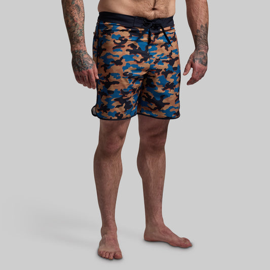 Camouflage swim shorts worn by a person on a gray background