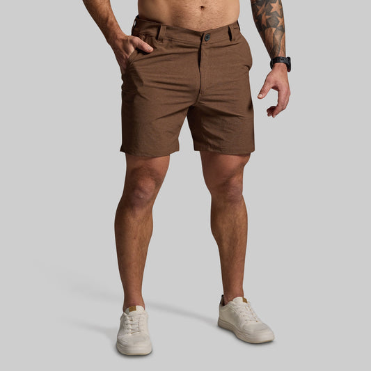 Person wearing brown shorts on a plain background