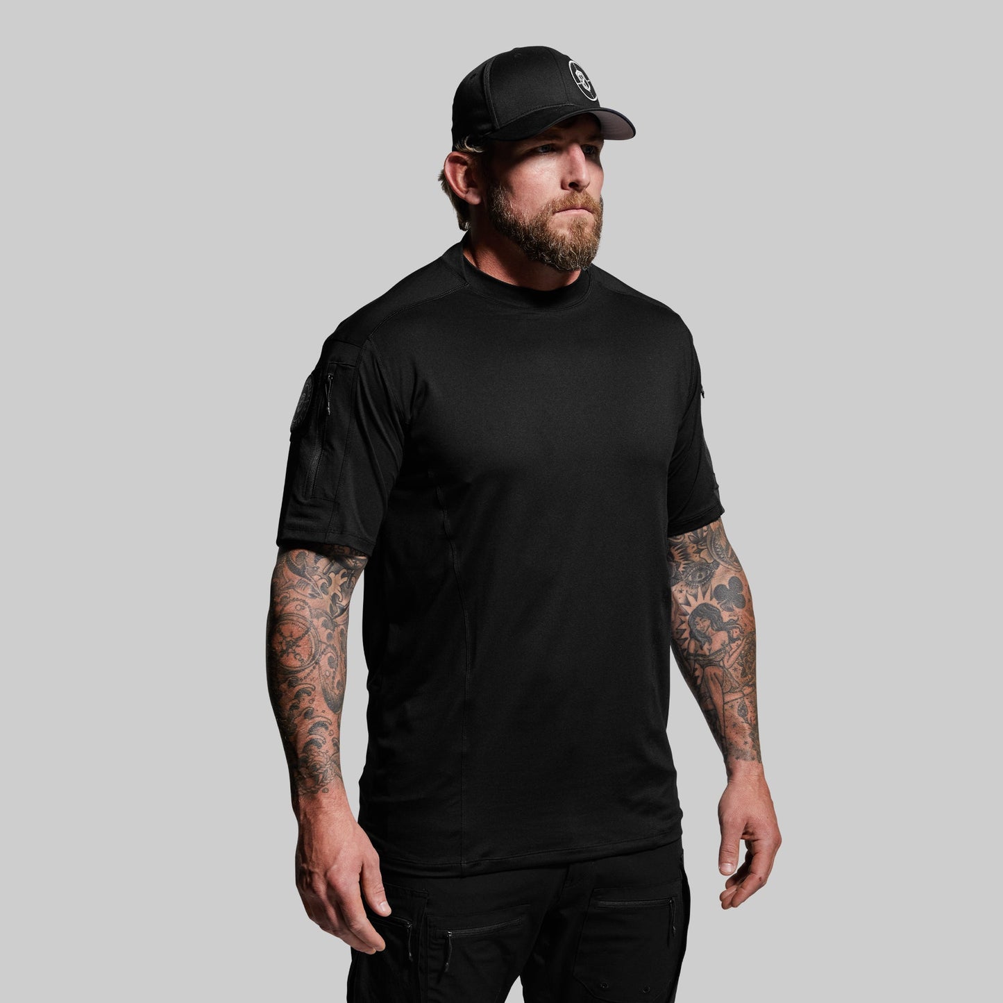 Man wearing a black t-shirt and cap on a gray background