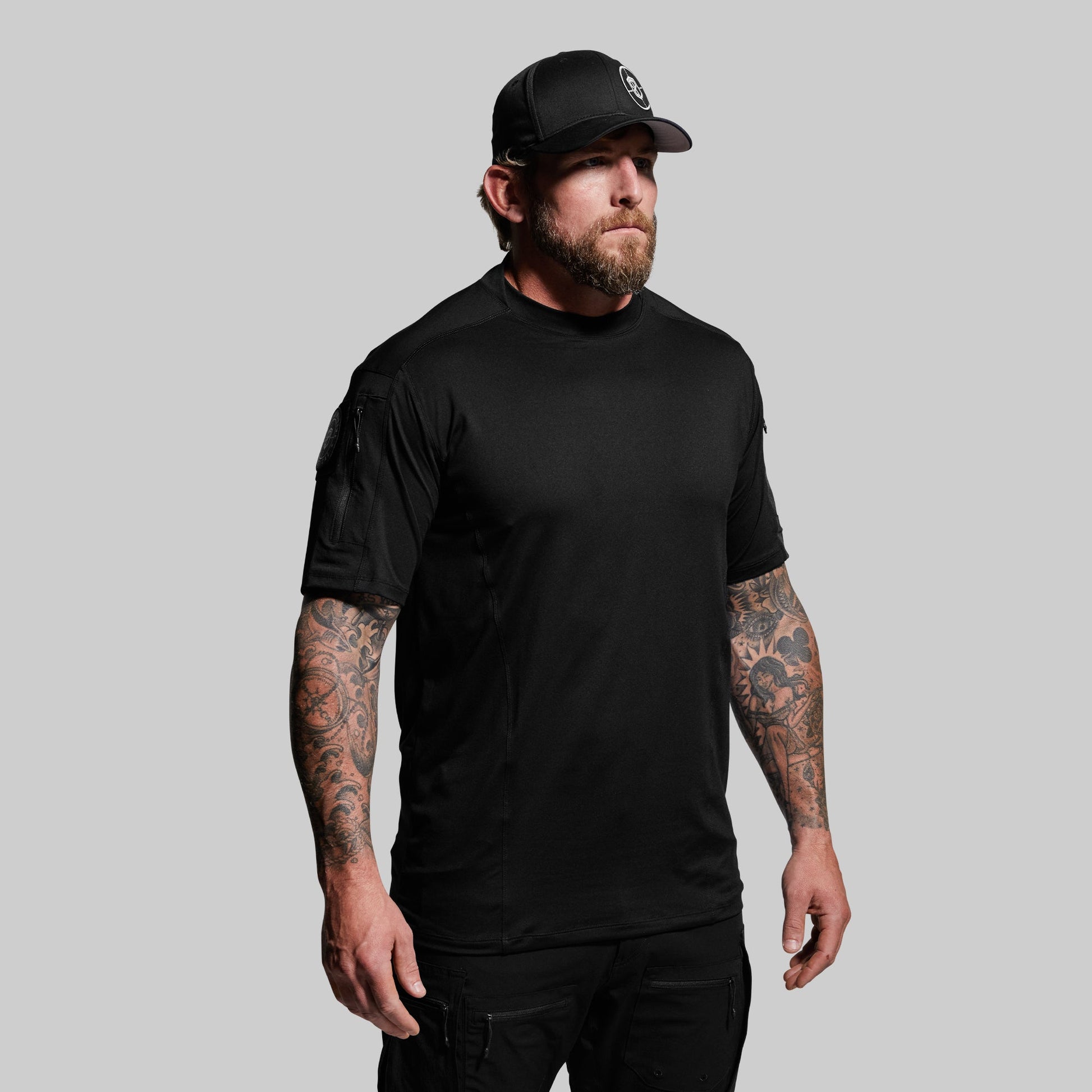 Man wearing a black t-shirt and cap on a gray background
